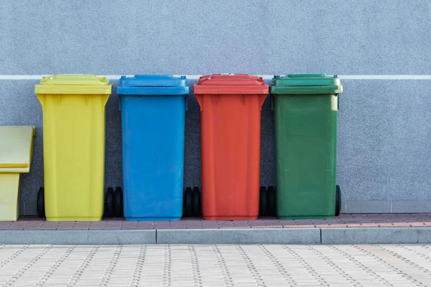 A row of different coloured wheelie bins. 