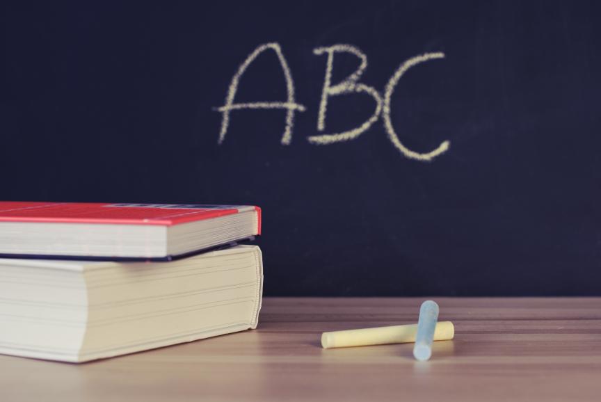 Blackboard with ABC Written on in Chalk with Books on the Desk 