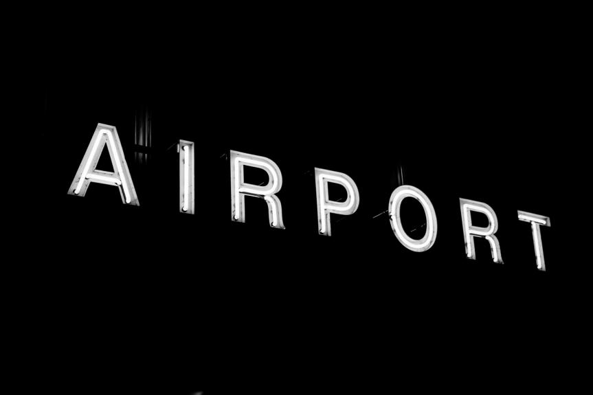 White Airport sign illuminated on black background 