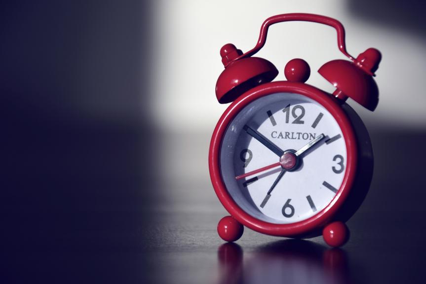 Red Alarm Clock on Wooden Table